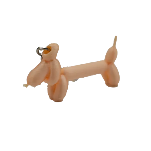 Sleutelhanger in de vorm van een ballonhond, gemaakt van beige plastic.