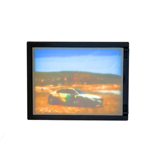 Een digitaal scherm toont een onscherpe afbeelding van een camouflageauto in een landschap met blauwe lucht en heuvels op de achtergrond.