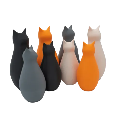 Een groep gestileerde kattenbeeldjes in de kleuren zwart, grijs, oranje en wit staan dicht bij elkaar.