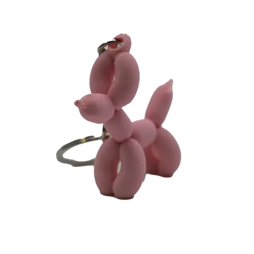 Roze ballon hondje sleutelhanger tegen een grijze achtergrond.