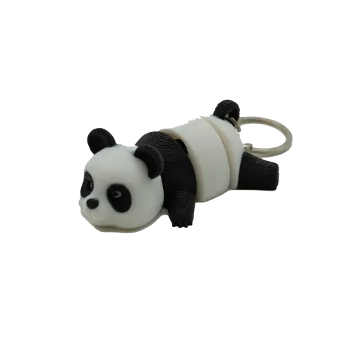Een sleutelhanger in de vorm van een liggende panda met zwart-witte kleuren.