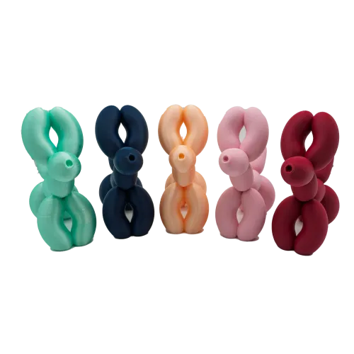 Vijf decoratieve sculpturen in de vorm van ballonhonden, in de kleuren mintgroen, donkerblauw, oranje, roze en rood.