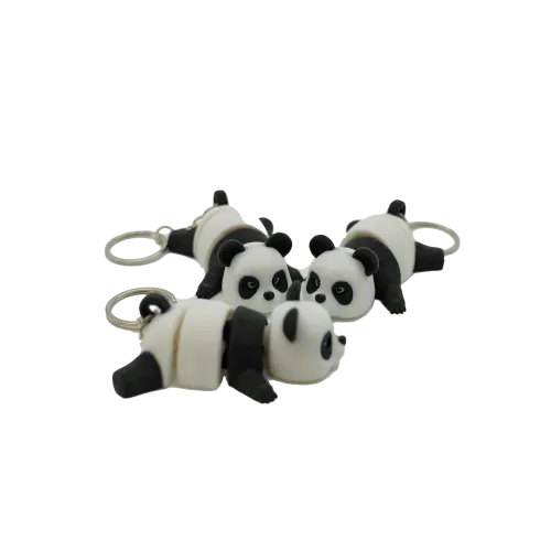 Vier schattige panda-sleutelhangers liggen op een witte achtergrond, elk met een zwart-wit kleurenschema en een metalen ring.